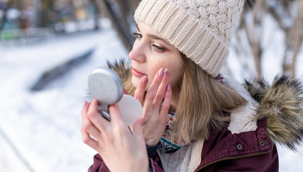 Mujer aplicandose protector solar en invierno